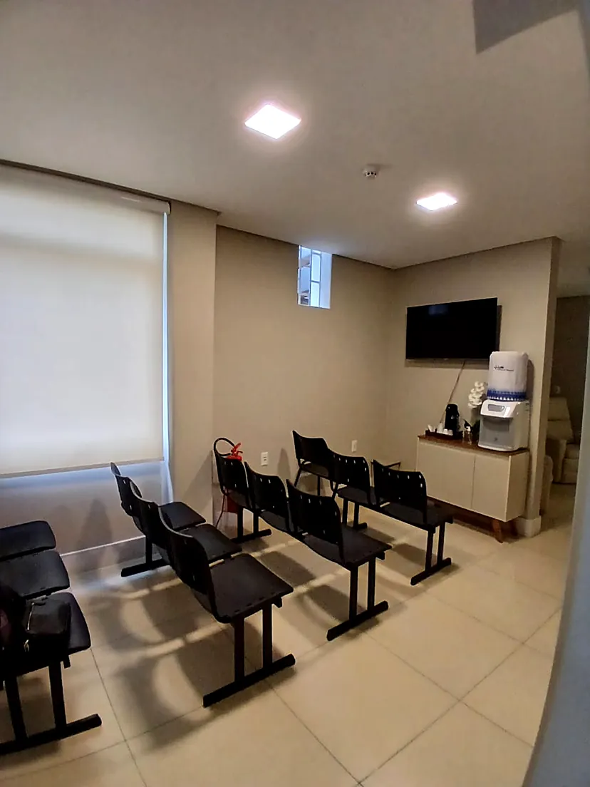 Sala de espera da LM Serviços Médicos, com cadeiras e televisão