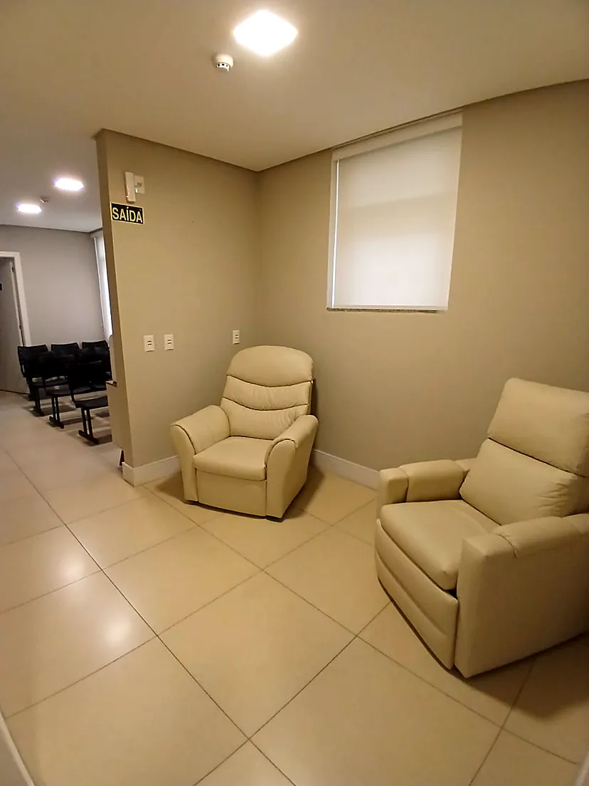 Sala com poltronas reclináveis e acesso à área de espera da clínica